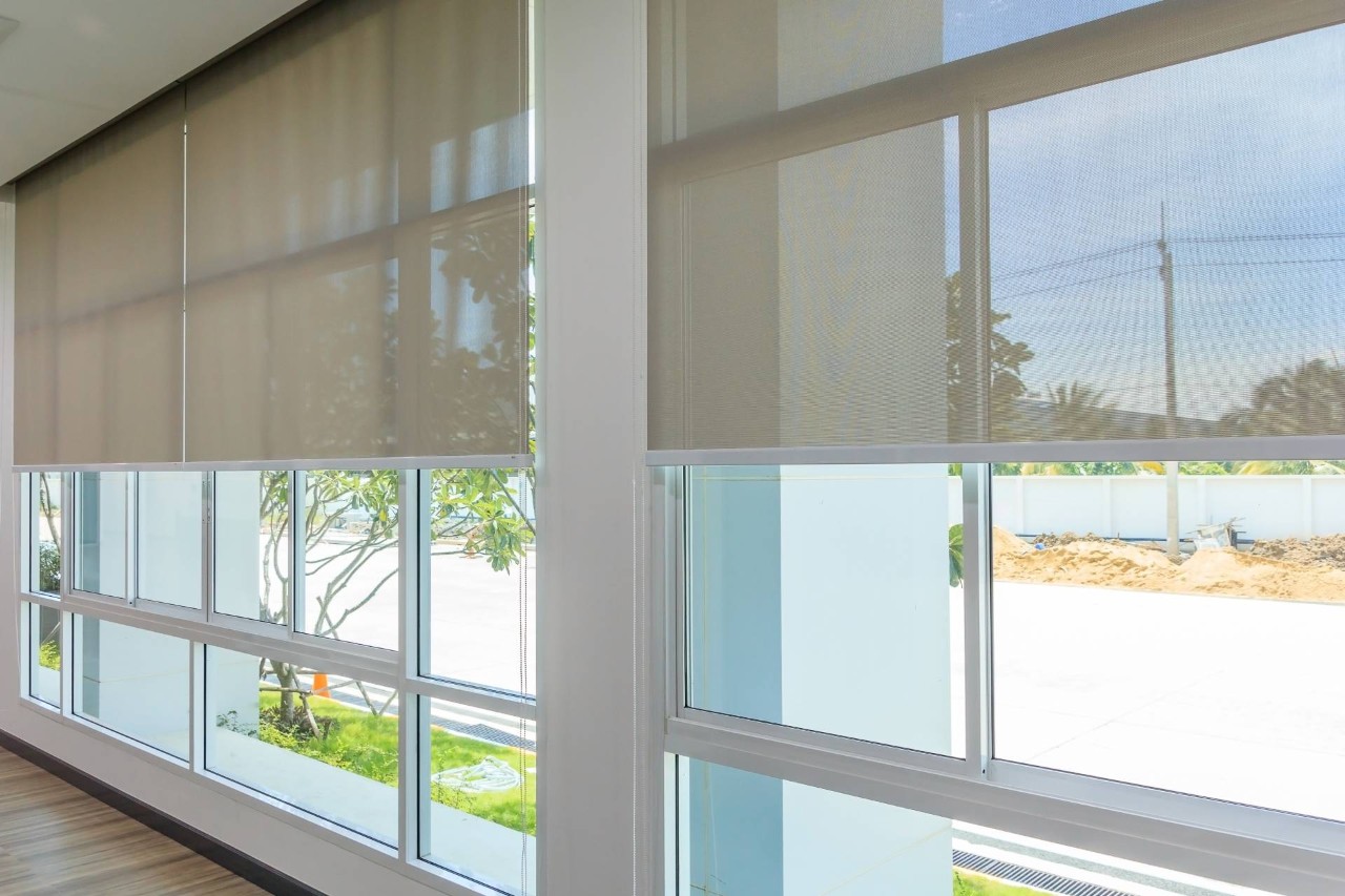 Automated roller shades on large windows in a home at Benchmark Shutters & Shades near Apex, NC